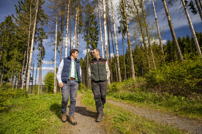 Das Bild zeigt Privatwaldbesitzer und einen Privatwaldbetreuer, die gemeinsam durch den Wald gehen.